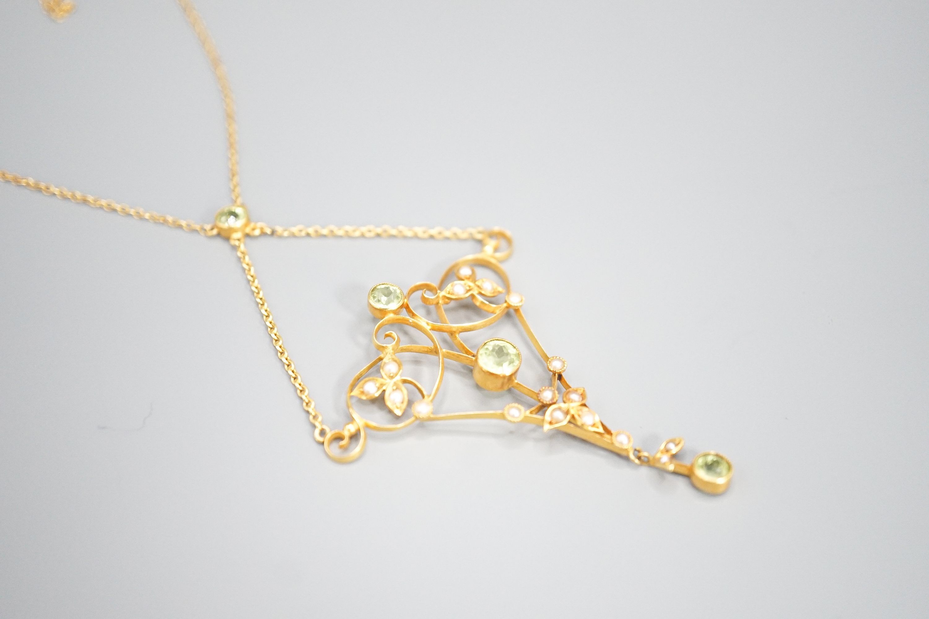 An Edwardian 9c yellow metal peridot seed pearl set pendant necklace, approx. 52cm overall, gross weight 4.4 grams.